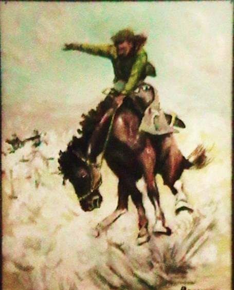 Painting of a cowboy on a bucking bronco