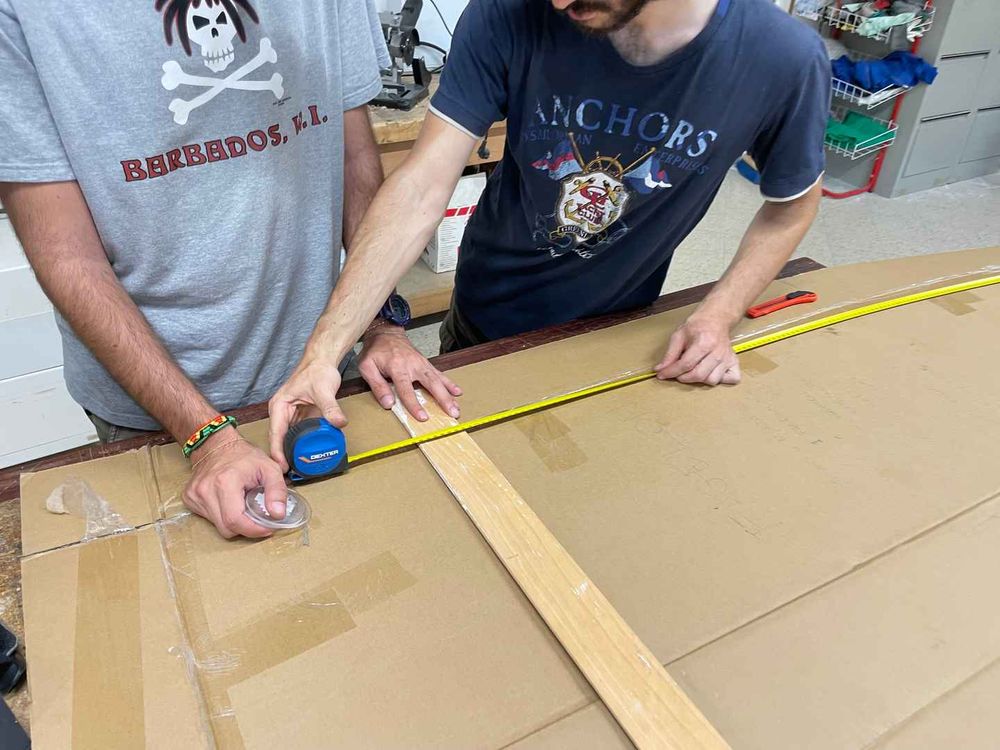 Maurizio and Pietro measuring the cardboard in order to cut it so that it matches my height.