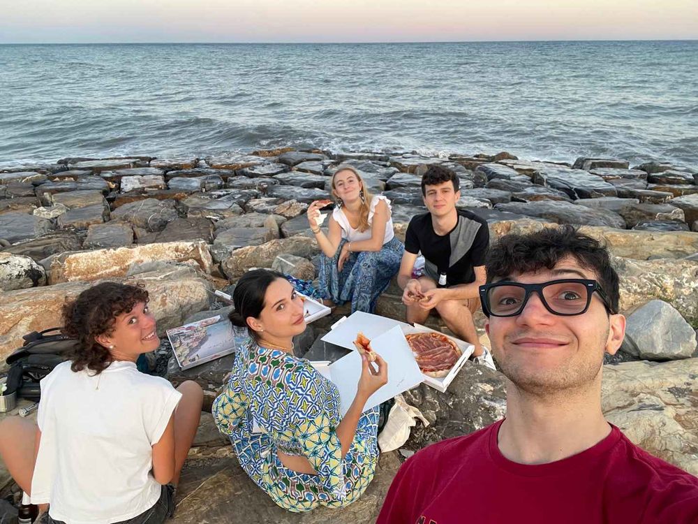 Selfie of the five of us sitting on rocks by the sea.