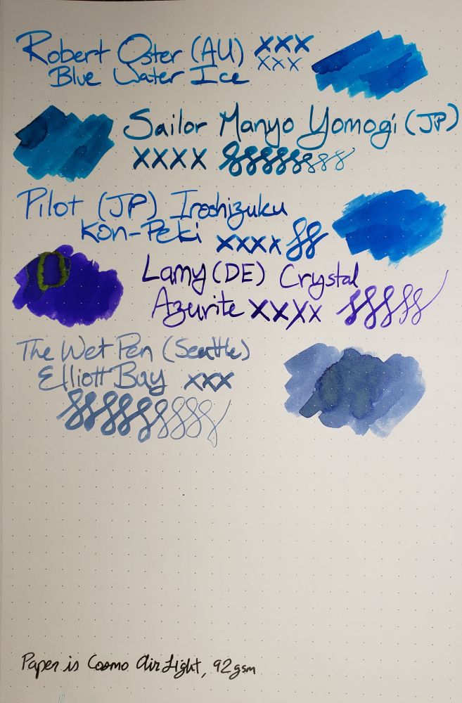 Ink swatches on white paper with light grey dot grid. Swatches are labeled with name of maker and line, ink name, and have 'x's, loops, and big sections of ink spread out.