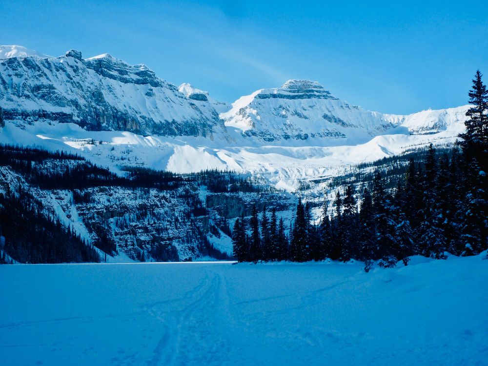 A snowy Headwall at the end of the lake which is highlighted by
sunshine under a perfect blue sky.