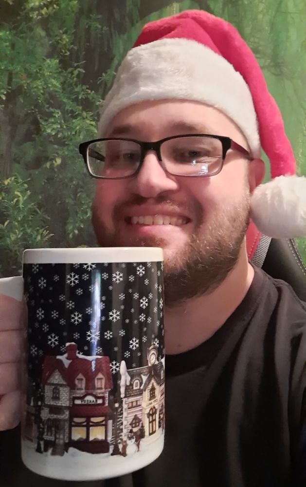 Me wearing a Santa hat and holding a winter mug 