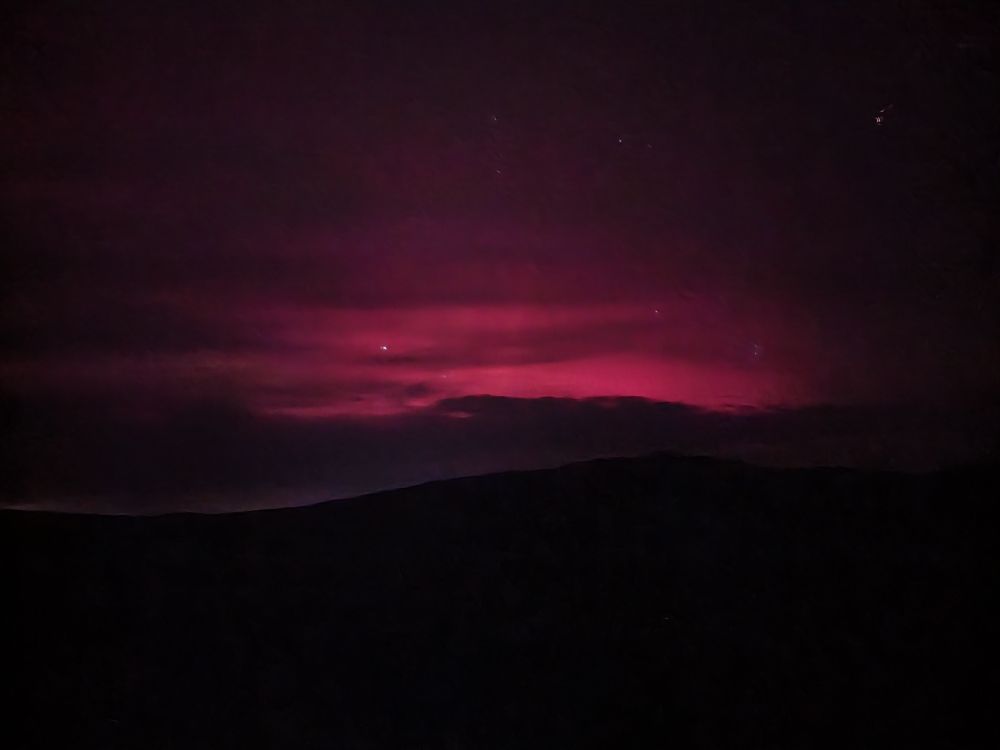 Red glow in sky with stars poking through. 
