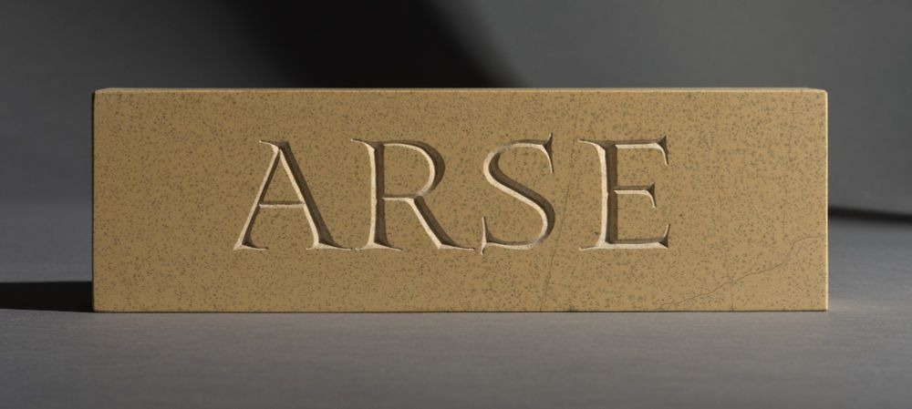 A block of limestone, hand carved with the word ARSE. This has been my most popular carving by a country mile. What can I say, everyone wants a rock hard arse.