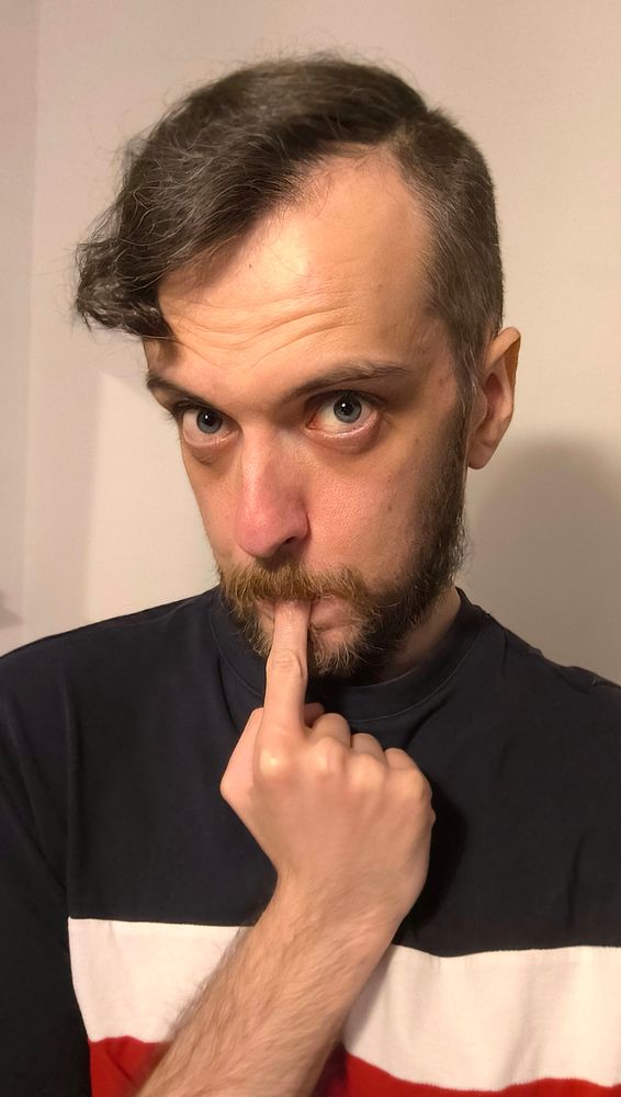 Me looking straight at the camera. A finger is in my mouth