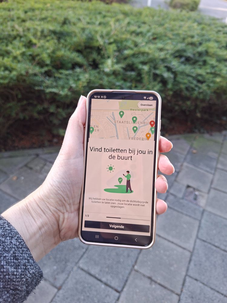 Hand die telefoon vasthoudt met daarop de Hoge Nood-app