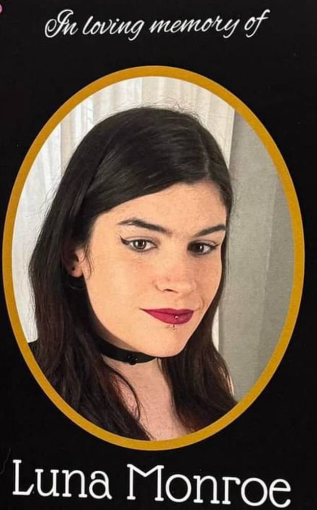 A picture of a young transgender woman with black hair and red lips. Above says “in loving memory of” and below says “Luna Monroe”