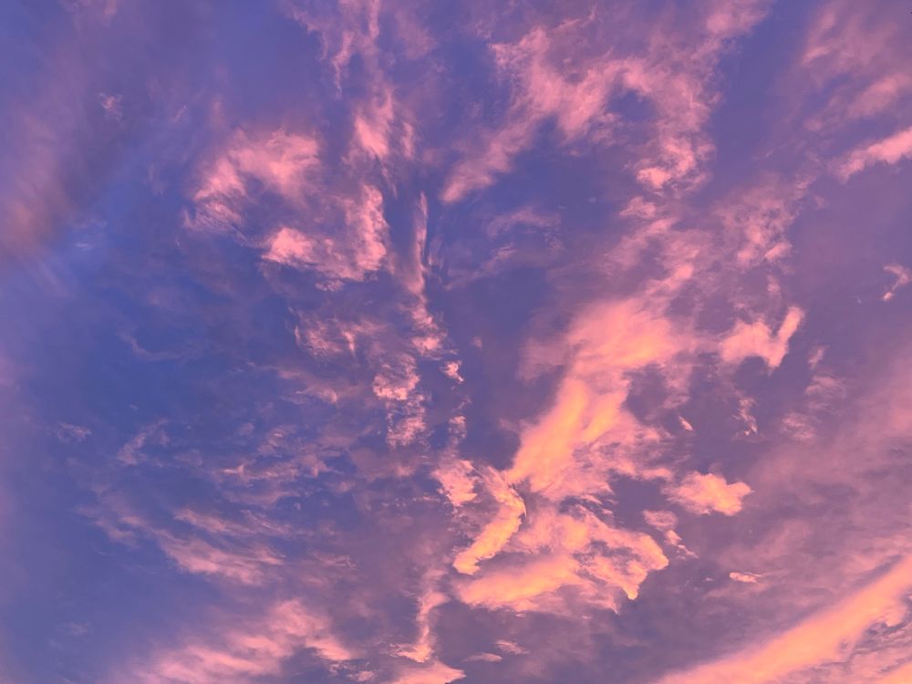 Photo of reddish pink clouds at sunset in a unique formation.