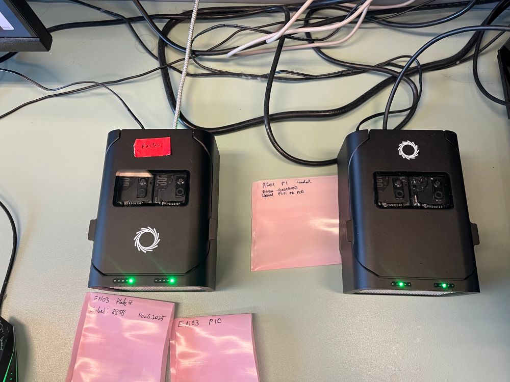 Two Oxford nanopore promethion sequencers sitting on a lab bench, each sequencing two flow cells each. One is labelled “Kassen” with red lab tape. 