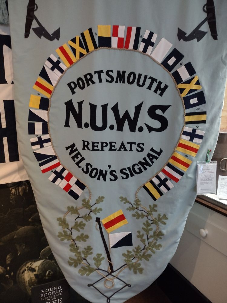 Banner for NUWS surrounded by naval signal flags.