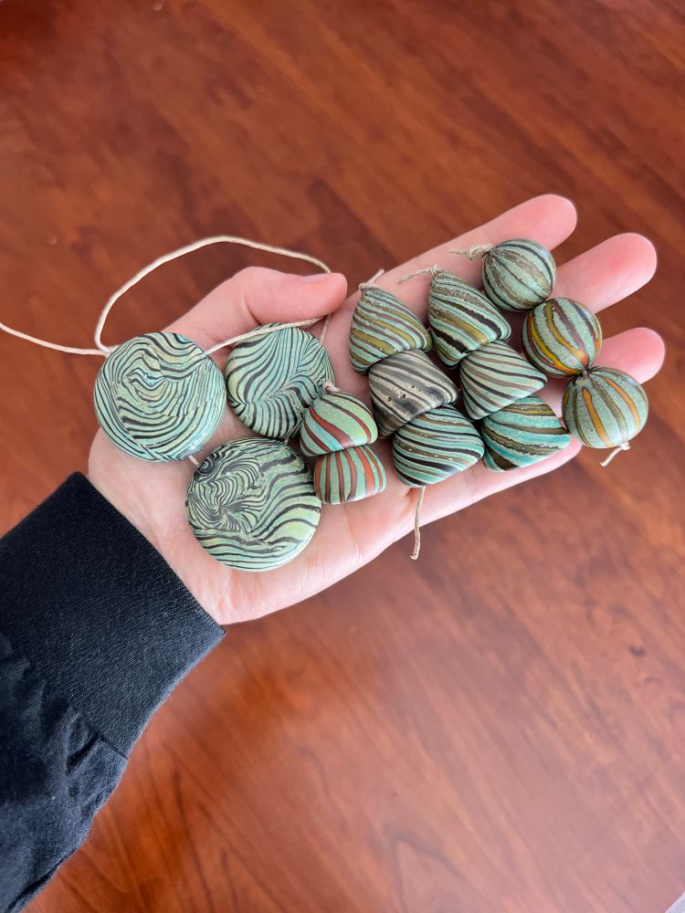 Verdigris base with coordinating stripe variations. These are all sold. Beads are off mandrel blown hollows that have been tumble etched for a matte appearance. Since they’re hollow, they’re light for their size. 