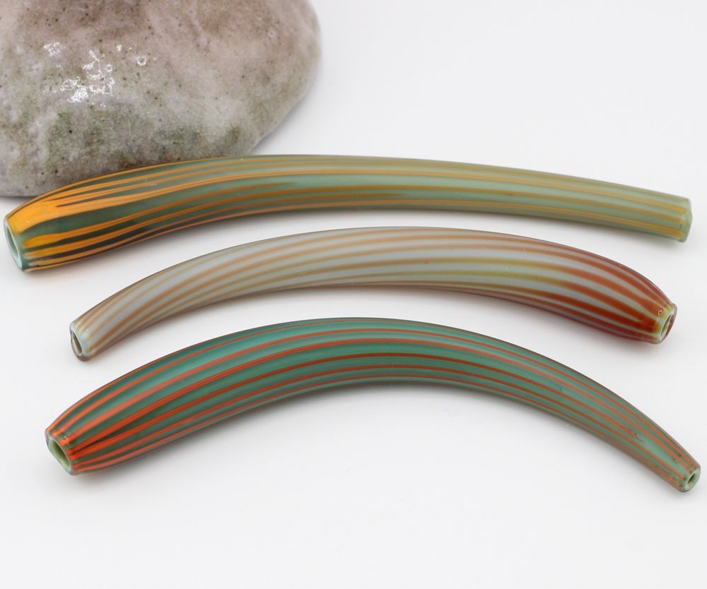 Blown glass tube bead trio in striped designs of varying colors of blue, red and orange. 