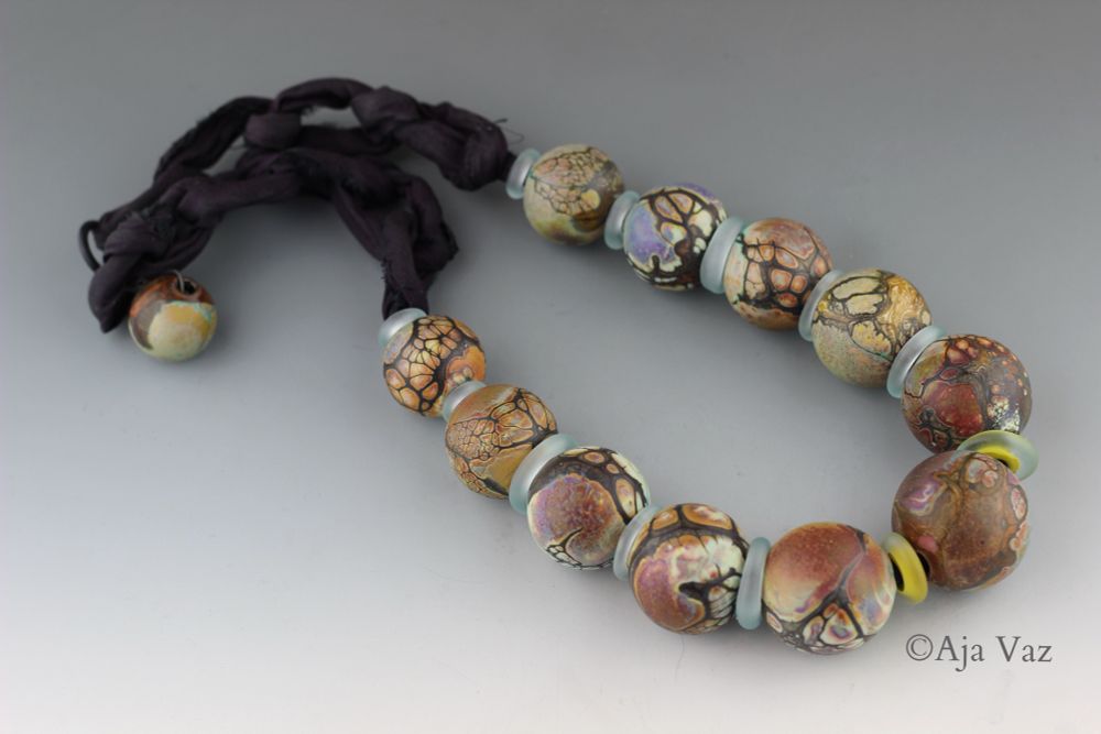 Blown glass bead necklace in earthy colors inspired by the succulents around me while stationed in TX a couple times. First El Paso, then San Antonio. I didn’t realize how colorful these desert plants could be. These were blown off mandrel, then tumble etched. This is more of a reminder to myself that I need to make some replacement beads since a few were broken during one of our PCS moves. I’ll probably try to match seed beads to the silk sari for more longevity. 