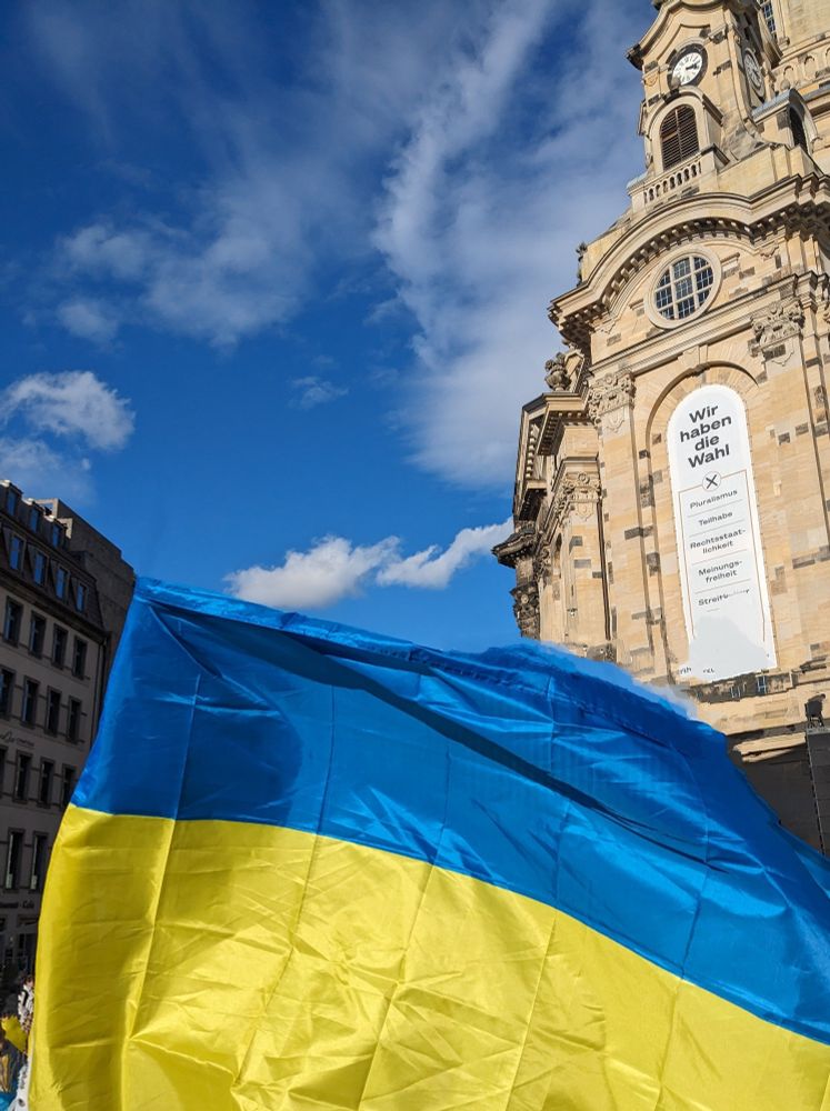 Ukraine-Kundgebung am 24.2.2024 auf dem Neumarkt in Dresden, im Vordergrund die ukrainische Flagge vor der Dresdner Frauenkirche.