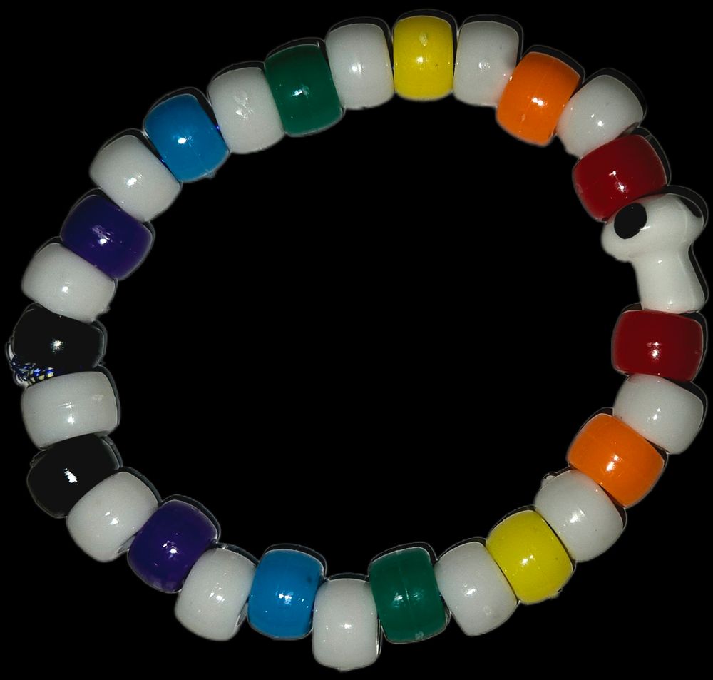 A kandi bracelets with a rainbow colour scheme. The coloured beads are spaced with a white bead. In between the first red beads is a white mushroom bead with black spots.
