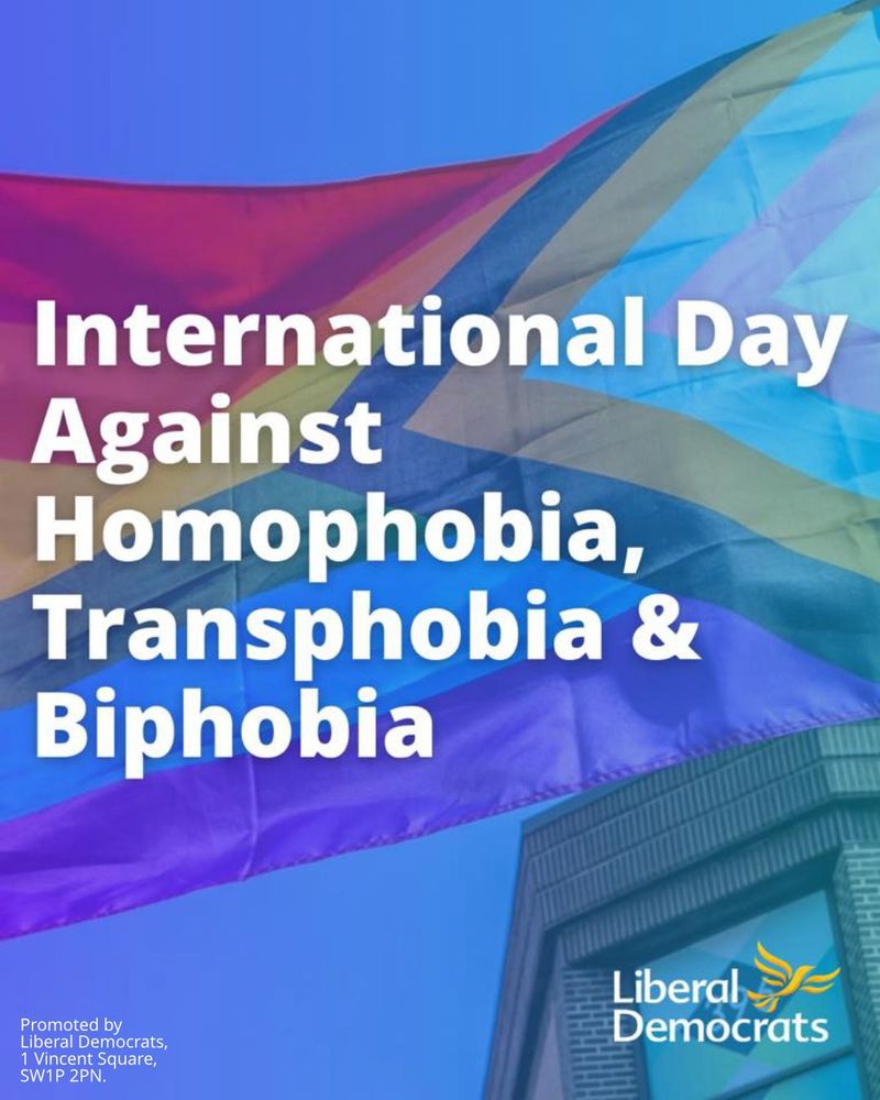 International Day Against Homophobia, Transphobia and Biphobia, against a bluish background photo of a Progress pride flag flying against a blue sky with a modern brick building just visible in the corner. The Liberal Democrat bird-of-liberty logo is in the bottom corner too.