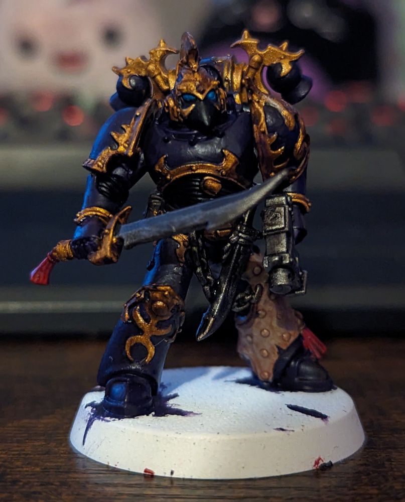 A Warhammer 40,000 miniature painted in purple and gold