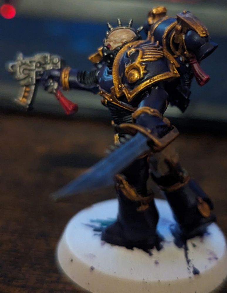 A purple and gold Warhammer 40,000 miniature