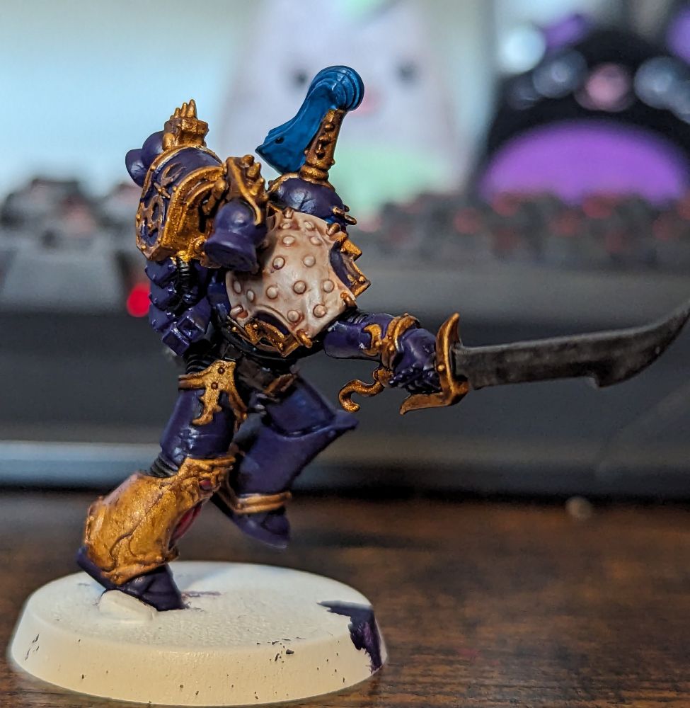 A Warhammer 40,000 miniature painted in purple and gold