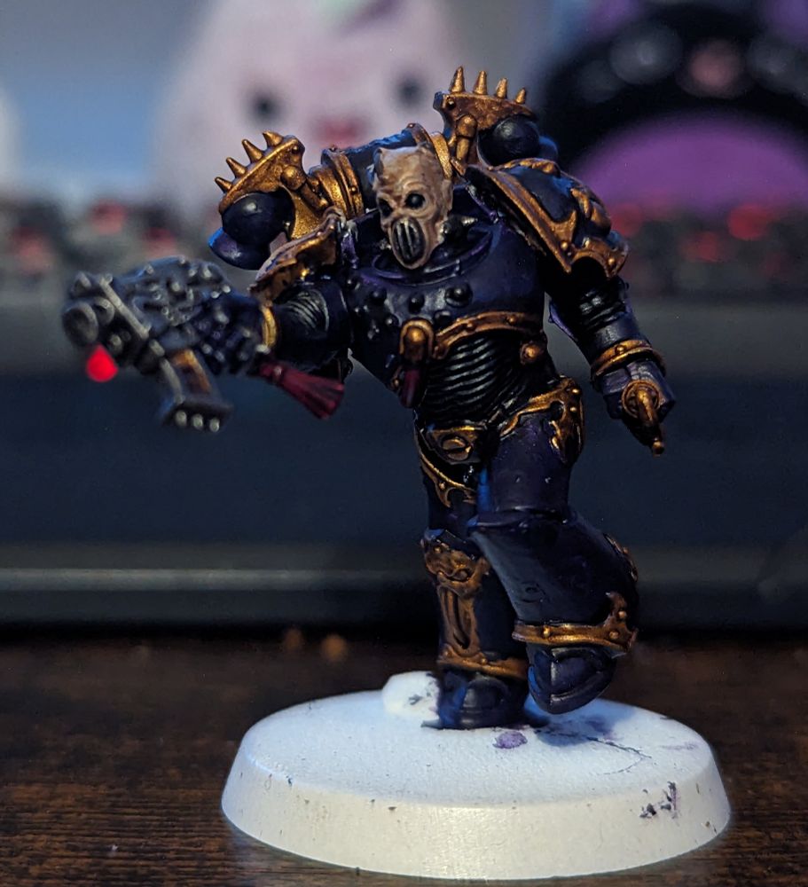A Warhammer 40,000 miniature painted in purple and gold