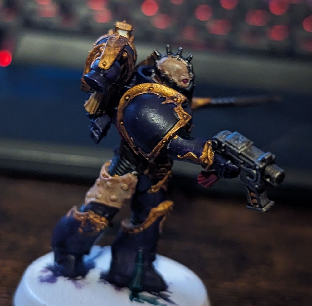 A purple and gold Warhammer 40,000 miniature
