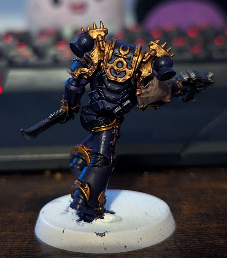 A Warhammer 40,000 miniature painted in purple and gold