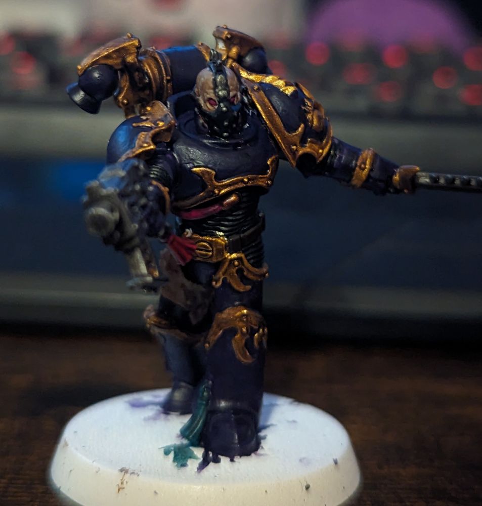 A purple and gold Warhammer 40,000 miniature