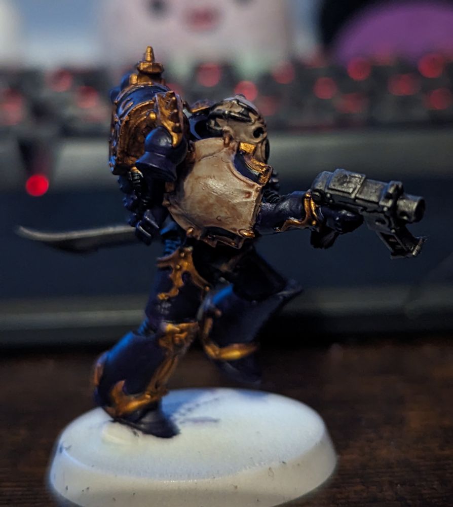 A Warhammer 40,000 miniature painted in purple and gold