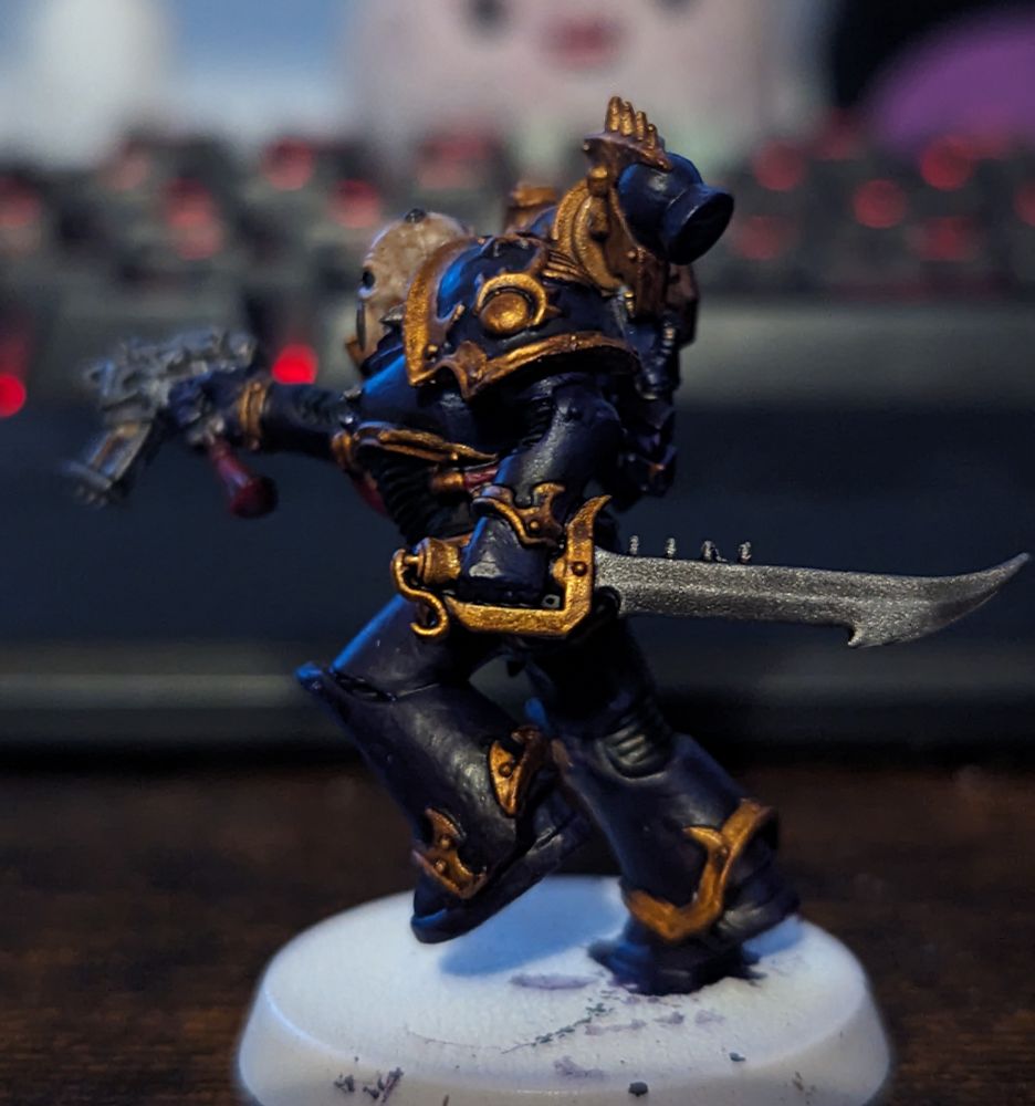 A Warhammer 40,000 miniature painted in purple and gold