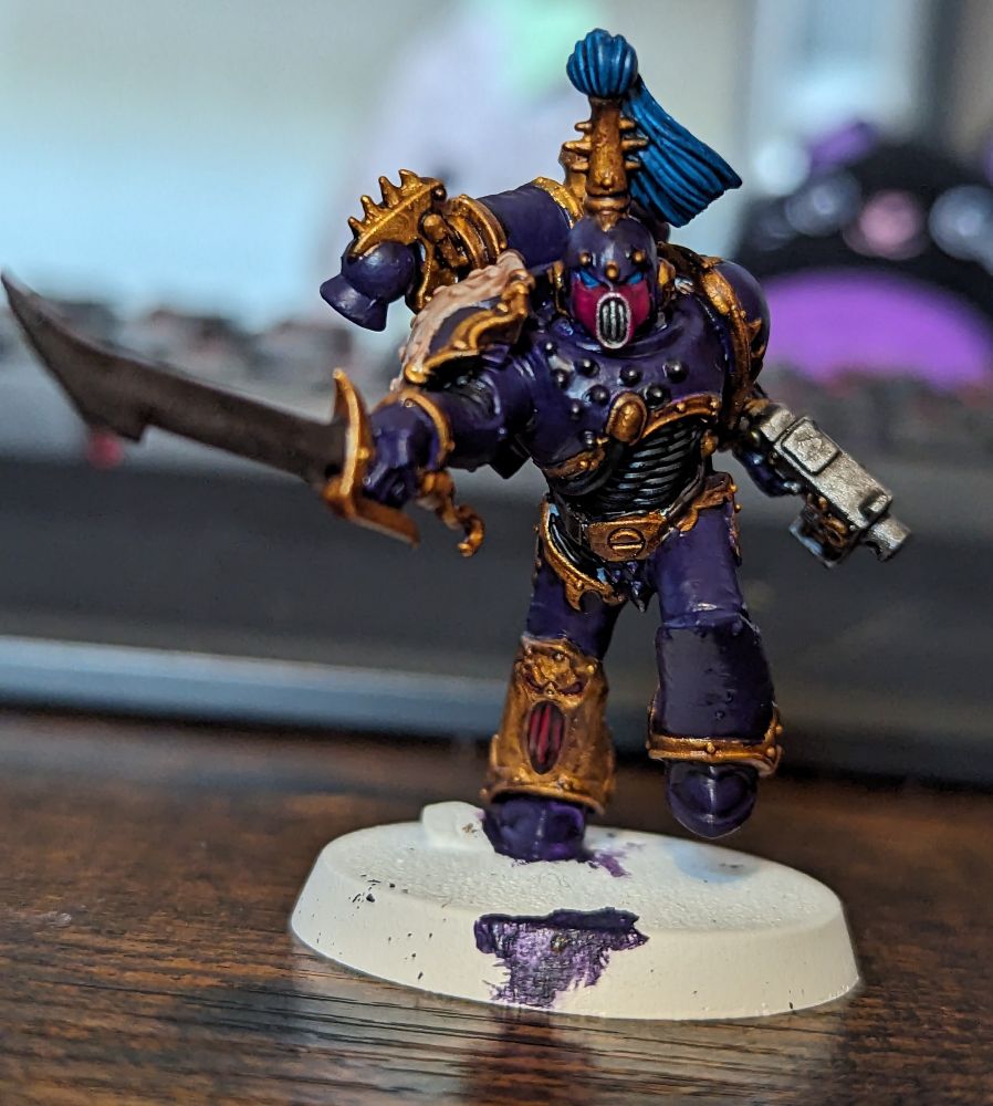 A Warhammer 40,000 miniature painted in purple and gold
