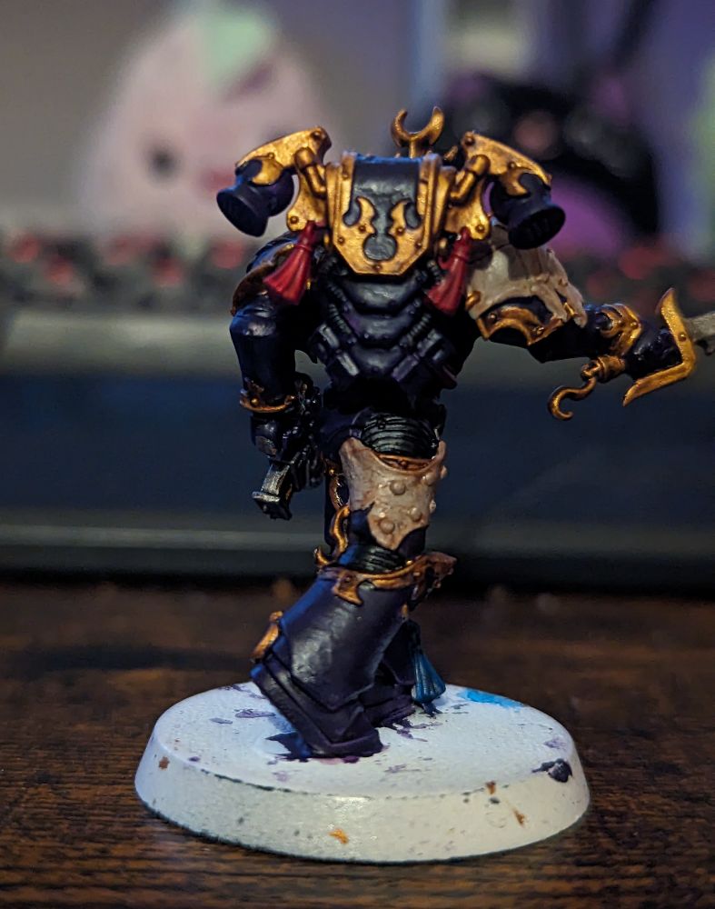 A Warhammer 40,000 miniature painted in purple and gold 