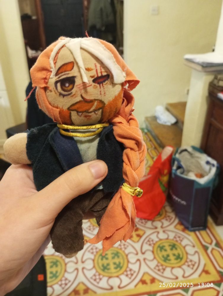 homemade plush of ops original character. plush is made almost entirely out of tshirt fabric except for the clothes and his face is drawn on with markers because op realised he doesnt know how to embroider far too late. he is being held like a trophy.