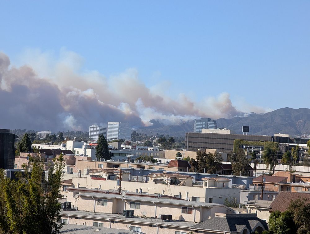 A photo of smoke rising from a fire in the Pacific Palisades 