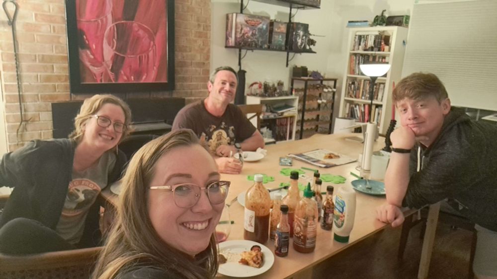 Four people playing board games, taking a selfie