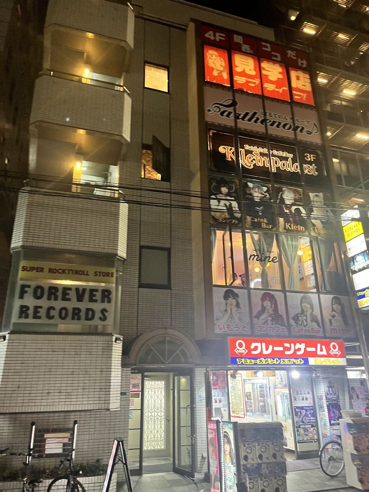 The sign for the record shop is visible (not on correct floor)  but the main shop front is a series of girls bar advertisements (at least I think that’s what they are)