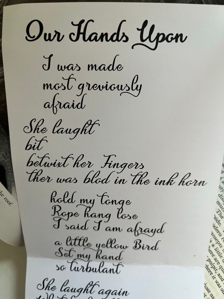 Written in beautiful script, a part of a poem, flowing down the folded page: 

Our Hands Upon

I was made most greviously afraid
She laught bit
betwixt her Fingers
Ther was blod in the ink horn old my Tonge
Lope hang lose said I am afrayd a little yellow Bird
Set my hand so Turbulant