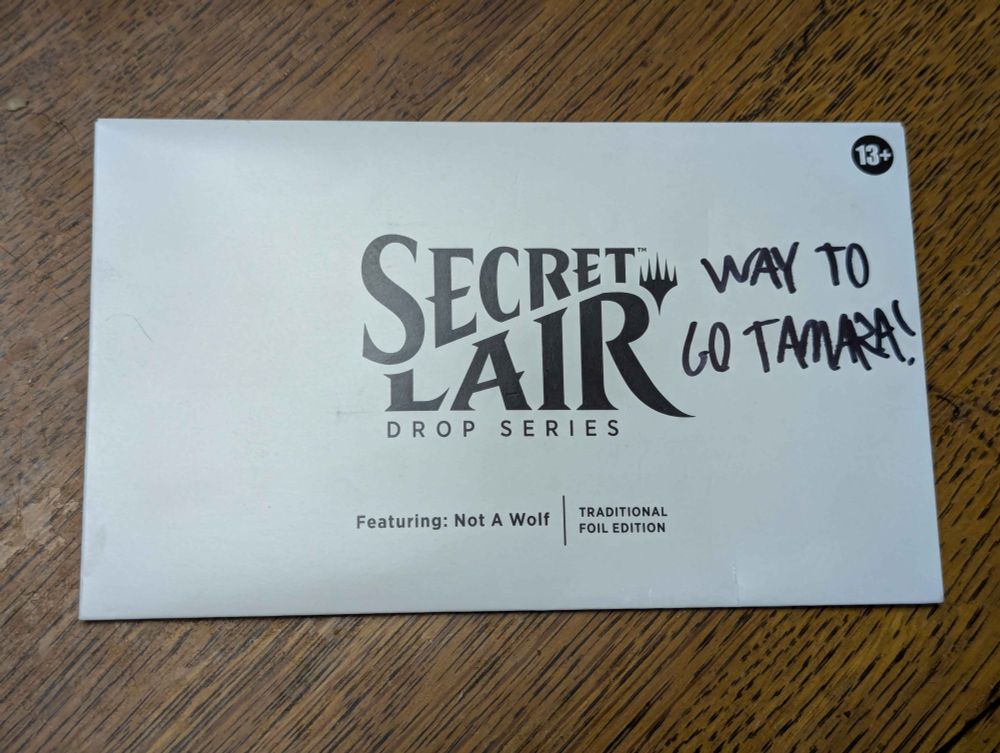The "Featuring: Not A Wolf" Secret Lair from Magic: The Gathering, with the text "WAY TO GO TAMARA!" messily scrawled onto the front.