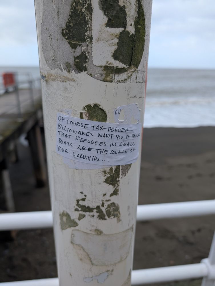 Sticker reading "of course tax dodger billionaires want you to think that refugees in small boats are the source of your hardships.