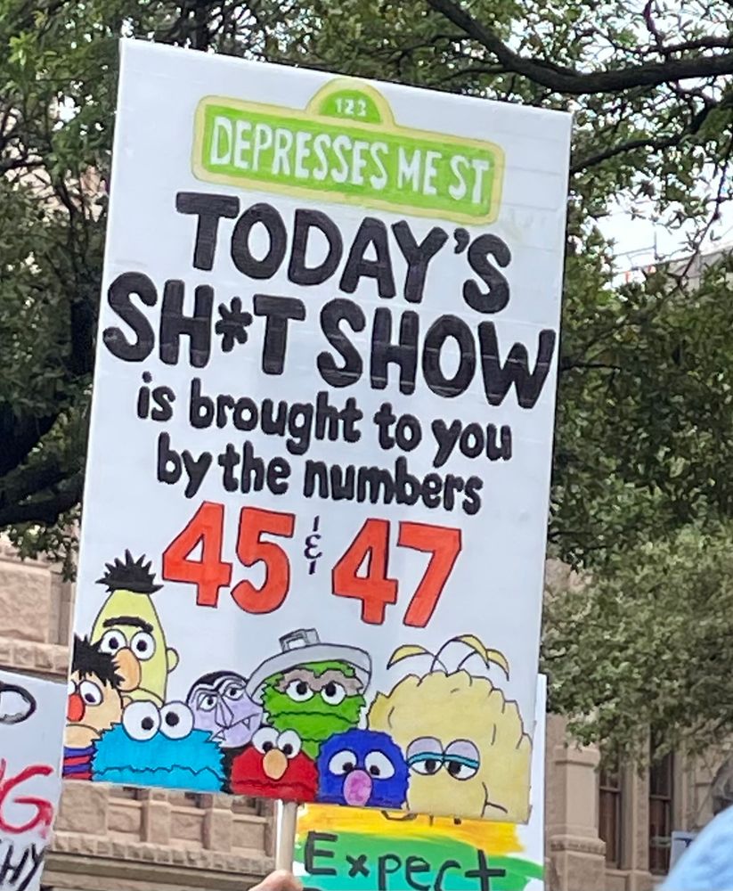 Sign at rally with Sesame Street characters on it. 