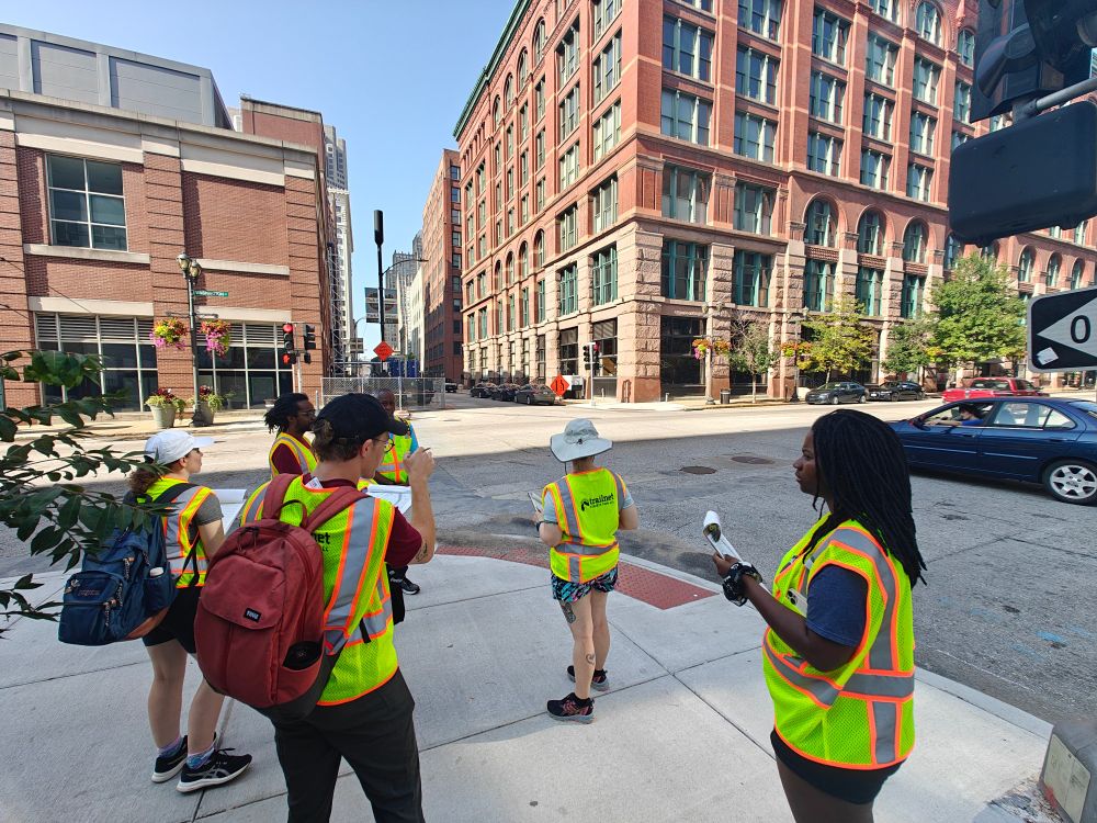 Trailnet staff members wearing hi-vis vests, taking notes about street conditions in downtown St. Louis
