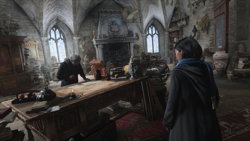 A screenshot from Hogwarts Legacy. A student talks with a teacher inside their classroom.