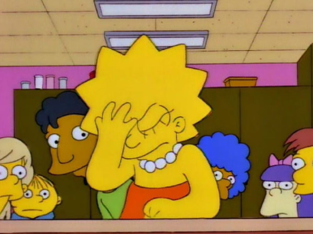 Lisa Simpson sat at her desk and facepalming