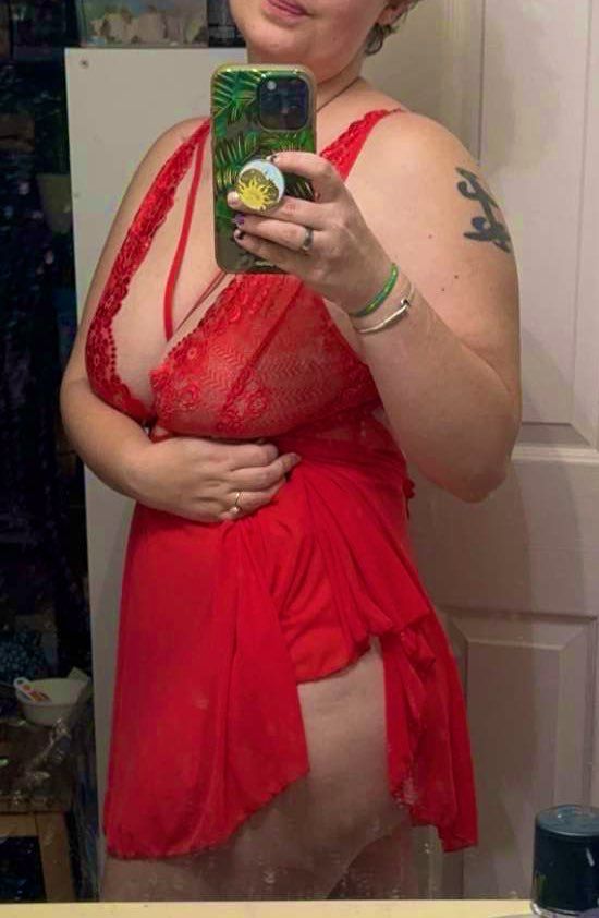 Edie is showing off a little ass while wearing a red lacy teddy dress 