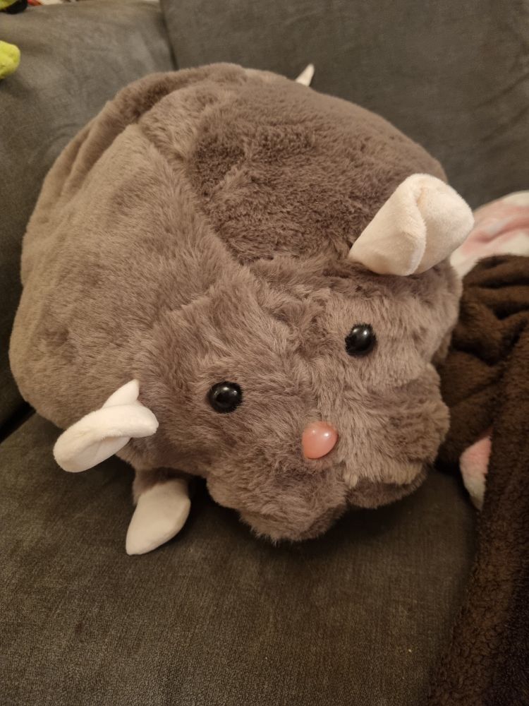 A chunky brown rat plushie with a pink nose and the cutest round black eyes ever. 