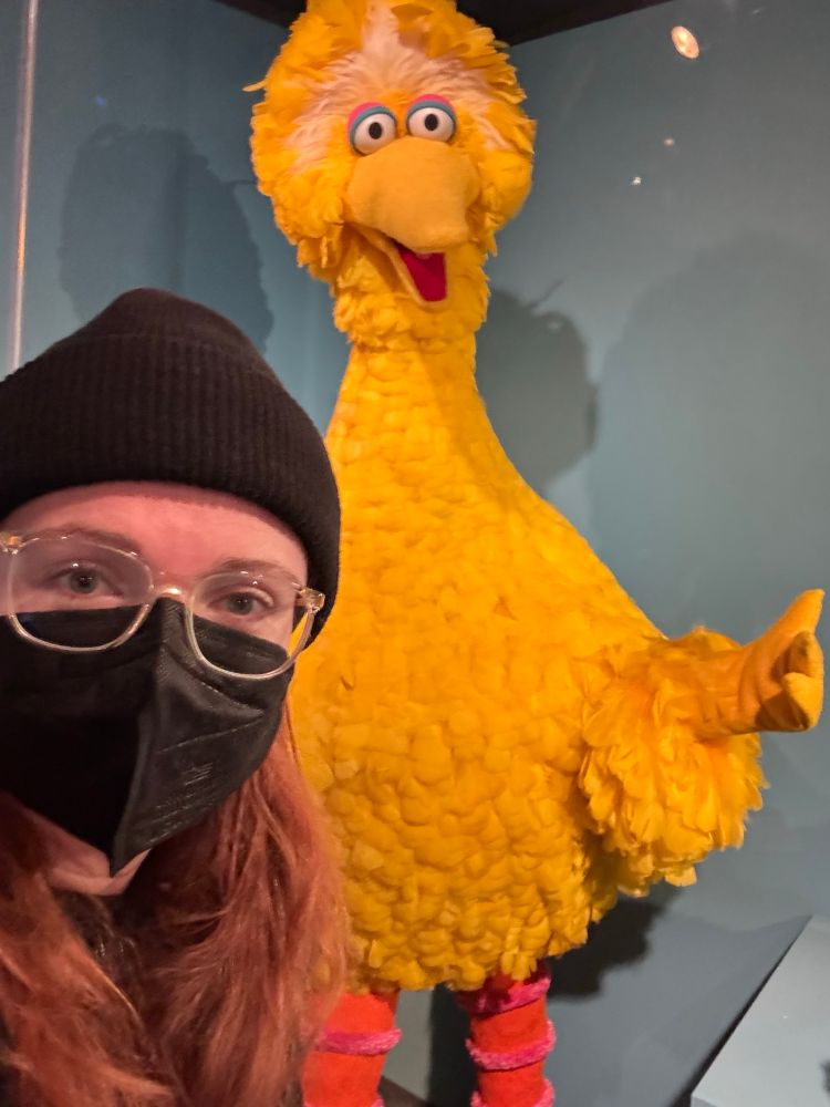 Me standing in front of Big Bird, a costume from the Jim Henson exhibit at the Museum of the Moving Image
