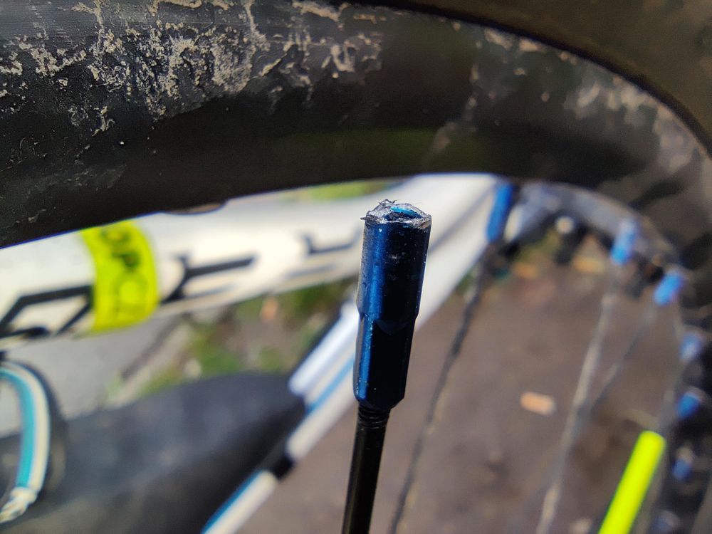 A broken wheel nipple. The part that serves as a nut holding the wheel spike in place.