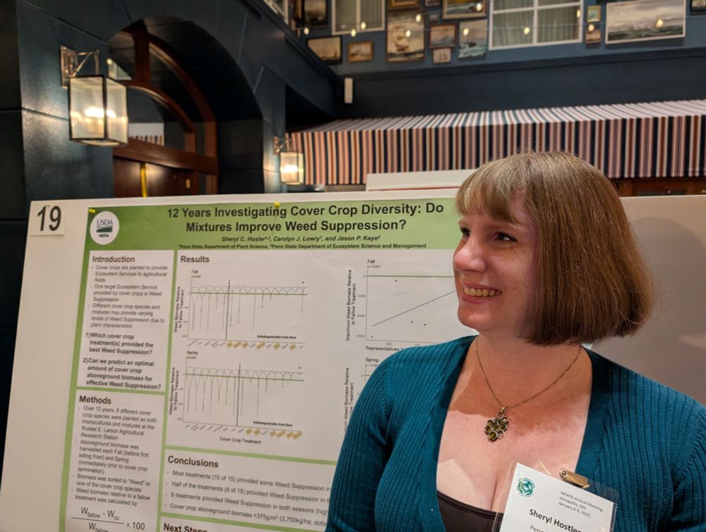 A close-up photo of Sheryl in profile standing in front of a green research poster.