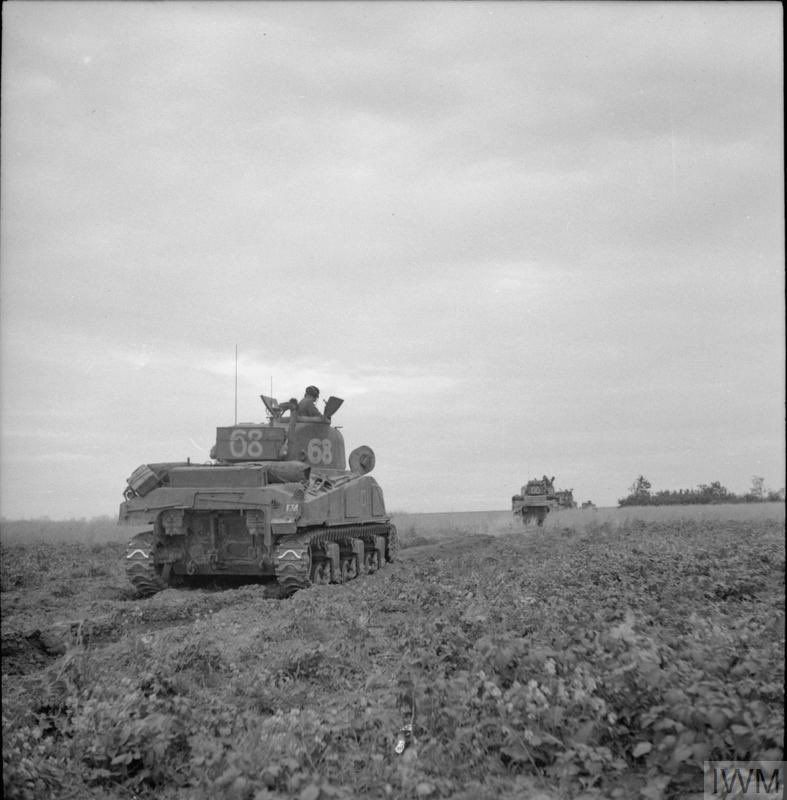 British tanks advance across fields.