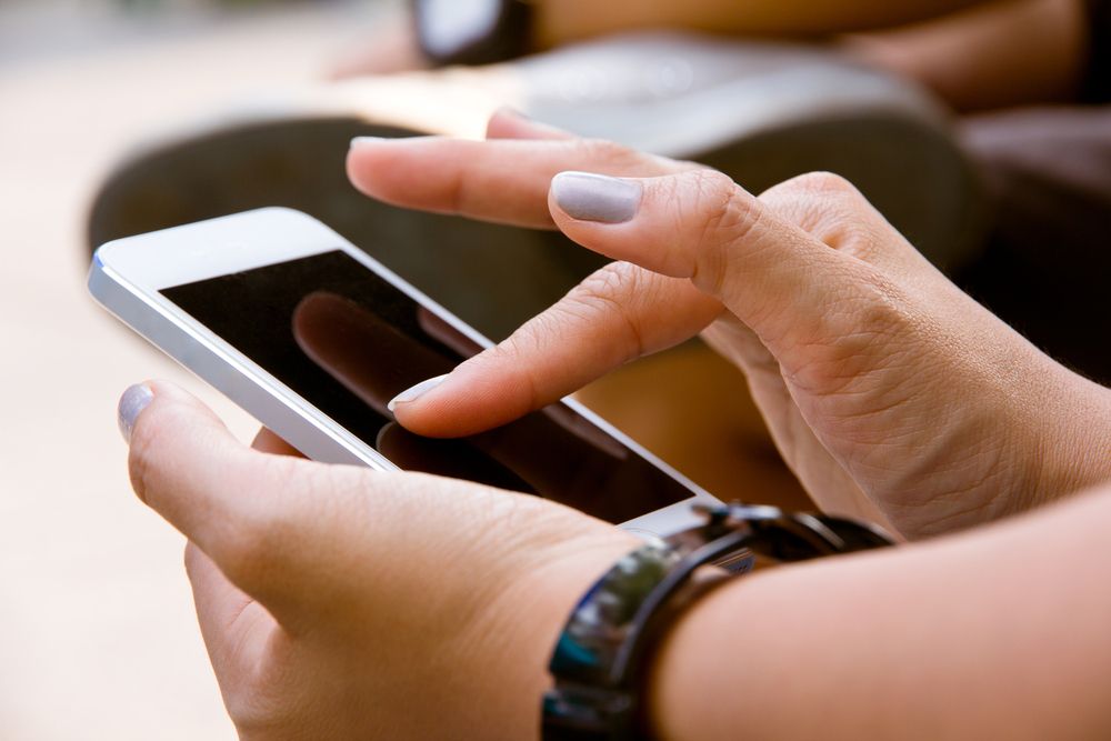 Hands holding and tapping on a mobile phone