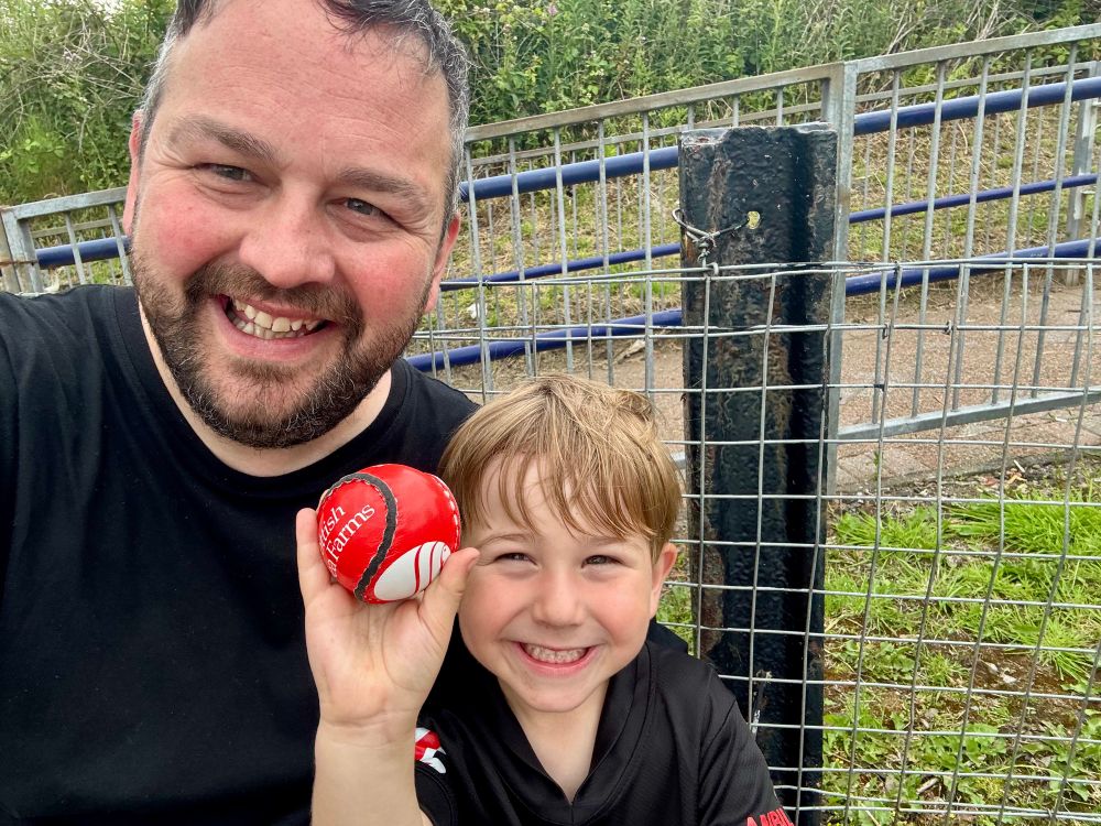 Me and my son holding up a red shinty ball after the game in Yoker Station. 